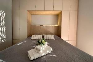 um quarto com uma cama com toalhas e flores em Ι Love Home Gold em Kalamata