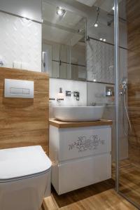 a bathroom with a white toilet and a sink at APARTAMENT BIAŁKA TATRZAŃSKA TATRY SUN&SNOW in Białka Tatrzańska