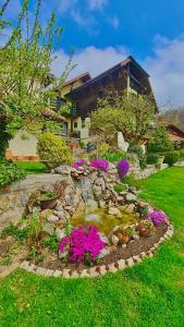 um jardim com flores cor-de-rosa em frente a uma casa em Vila Djordjevic - Priroda vas okruzuje em Brus
