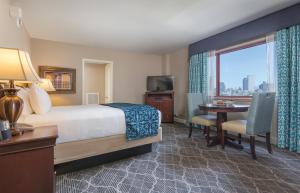 a hotel room with a bed and a table and a window at Club Wyndham Avenue Plaza in New Orleans