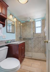 a bathroom with a shower with a toilet and a sink at Club Wyndham Avenue Plaza in New Orleans