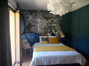 1 dormitorio con 1 cama con una pintura en la pared en Villa Bleucassis, en Taradeau