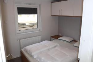 een kleine slaapkamer met een bed en een raam bij Chalet Mariënberg in Mariënberg