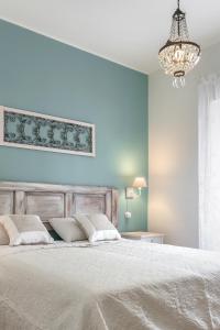 a bedroom with a white bed and a chandelier at Riva San Zeno - Mood Apartments in Verona