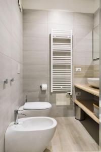 La salle de bains blanche est pourvue de toilettes et d'un lavabo. dans l'établissement La Casa di Greta, à Vérone