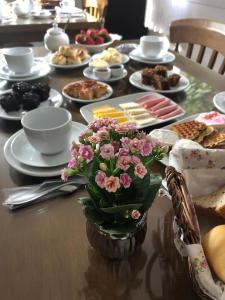 a table with plates of food and flowers on it at Pousada Beija Flor Centro in Gramado