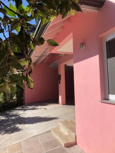 a pink wall of a house with a window at Pousada Beija Flor Centro in Gramado