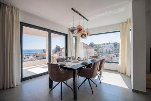 a dining room with a table and chairs and a large window at Villa Sea Silhouette in Žman