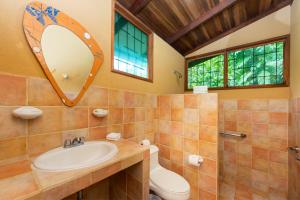 a bathroom with a sink, toilet, and bathtub at Laguna Lodge in Tortuguero