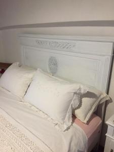 - un lit blanc avec une tête de lit et des oreillers blancs dans l'établissement Cà del Bunimur, à Magliano Alpi