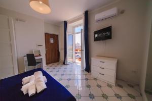 een slaapkamer met een blauw bed en handdoeken bij Casa Adele b&b in Pozzuoli