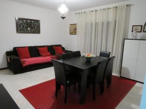 sala de estar con mesa negra y sofá rojo en apartamento Vila do Conde, en Vila do Conde