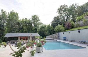 a swimming pool in a yard with a house at Mur-Mûres in Mûres-les Balmettes