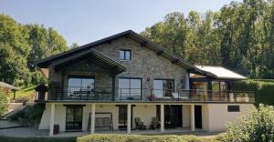 une maison avec un balcon au-dessus dans l'établissement Mur-Mûres, à Mûres-les Balmettes