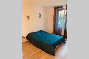 ein Schlafzimmer mit einem grünen Bett in einem Zimmer mit einem Fenster in der Unterkunft Bel Appartement calme dans villa Provençale in Montboucher-sur-Jabron
