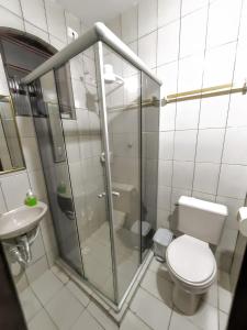 uma casa de banho com um chuveiro, um WC e um lavatório. em Pousada Iasbeck em Santa Rita de Jacutinga
