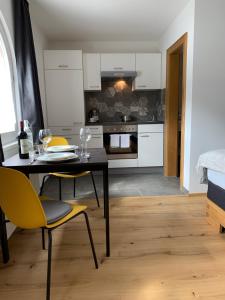 a kitchen with a dining table and yellow chairs at Landhaus Luzia in Wald am Arlberg
