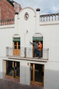two men standing on a balcony of a building at Ca l'Espavil in Cardedeu
