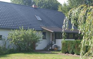 uma casa branca com um telhado preto em Beautiful Home In Zechin- Friedrichsaue With Kitchen em Friedrichsaue