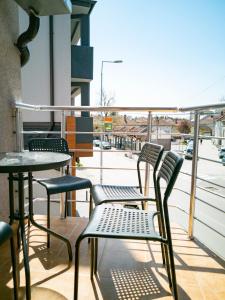 drie stoelen en een tafel op een balkon bij Lux Family Apartment Vidanovic in Pirot