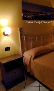 ナポリにあるB&B Terra Mia Napoliのベッドルーム1室(ベッド1台、ランプ付きのナイトスタンド付)