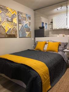 um quarto com uma cama grande e almofadas amarelas em Meni Sweet Central Studio em Volos