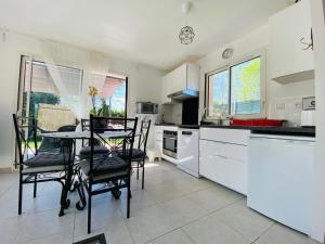 a kitchen with a table and some chairs in it at Le gîte du golf in Montauban