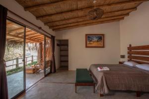 a bedroom with a bed and a sliding glass door at Kasa Pelikanos in Vichayito