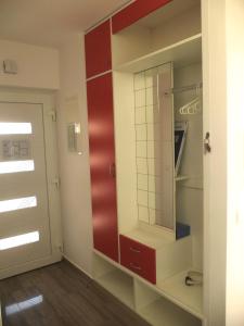 Cette chambre comprend une armoire rouge avec un miroir. dans l'établissement Apartment Ivy2, à Lovran