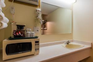 a microwave sitting on a counter next to a sink at The Ranchland Inn Kamloops in Kamloops +61 photos
