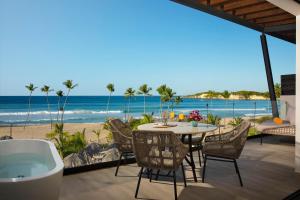 a patio with a table and chairs and the beach at Dreams Macao Beach Punta Cana in Punta Cana