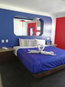 a bedroom with a bed with two white swans on it at MOTEL SENA in Ensenada