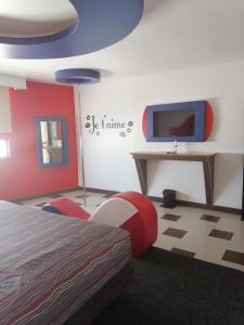 a bedroom with a bed and a tv on a wall at MOTEL SENA in Ensenada