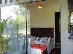 パッソ・デ・トーヘスにあるPousada Casa de Ferroのベッドルーム1室(ベッド1台、大きな窓付)