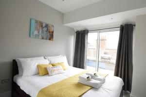 sypialnia z białym łóżkiem i oknem w obiekcie Northside Apartments Ealing w Londynie