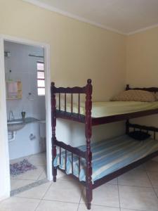 a bedroom with a bunk bed and a bathroom at Maydã in Praia Grande