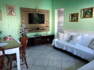 sala de estar con sofá y árbol de Navidad en Roseli's Vacation Home, en Gramado