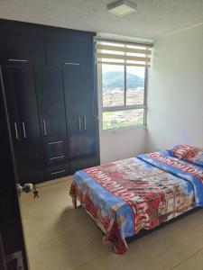 a bedroom with a bed and a window at Apto Moderno Sta Rosa de Cabal (termales) in Santa Rosa de Cabal