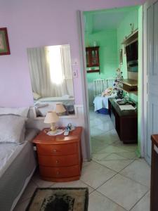 1 dormitorio con 1 cama y 1 mesa con lámpara en Roseli's Vacation Home, en Gramado