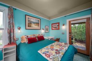 Dormitorio azul con cama y ventana en Secluded 2 Bdm Patio Villa Right By All The Action, en Portland