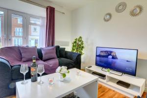 a living room with a couch and a tv at 2-BR Apartment, En-suite, Allocated Parking, next to Playground in Coventry