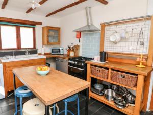 a kitchen with a table and a stove top oven at Spring Cottage in Ilfracombe