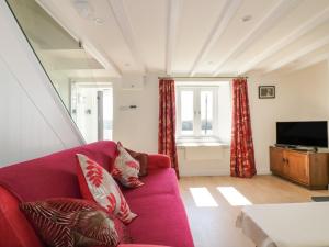 a living room with a purple couch and a tv at Puffin Cottage in Truro