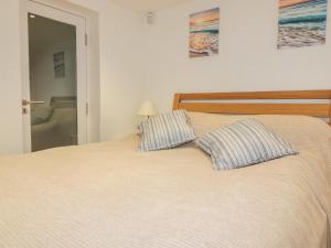 a bedroom with a bed with two pillows on it at Puffin Cottage in Truro