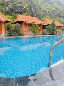duży niebieski basen przed budynkiem w obiekcie Trang An Lotus Lake Homestay w mieście Ninh Binh