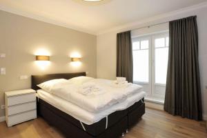 Schlafzimmer mit einem großen weißen Bett und einem Fenster in der Unterkunft Haus Doktor Ross Strasse 31 Whg 4 in Westerland