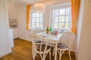 a dining room with a white table and chairs at Haus Heefkant Whg 10 in Rantum