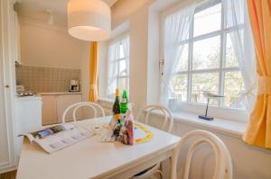 una cucina con un tavolo con bottiglie e sedie di Haus Heefkant Whg 10 a Rantum Altre 10 foto