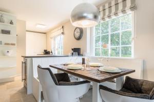 une salle à manger avec une table, des chaises et une horloge dans l'établissement Haus Suederhof Whg 13 Seemoewe, à Keitum