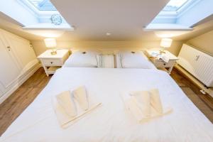 1 dormitorio con 1 cama blanca grande y tragaluces en Alte Stadtgaertnerei Whg 21, en Westerland